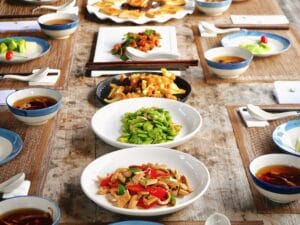 Mesa com diversos alimentos saudáveis servidos em pratos, representando uma alimentação equilibrada e rica em nutrientes.