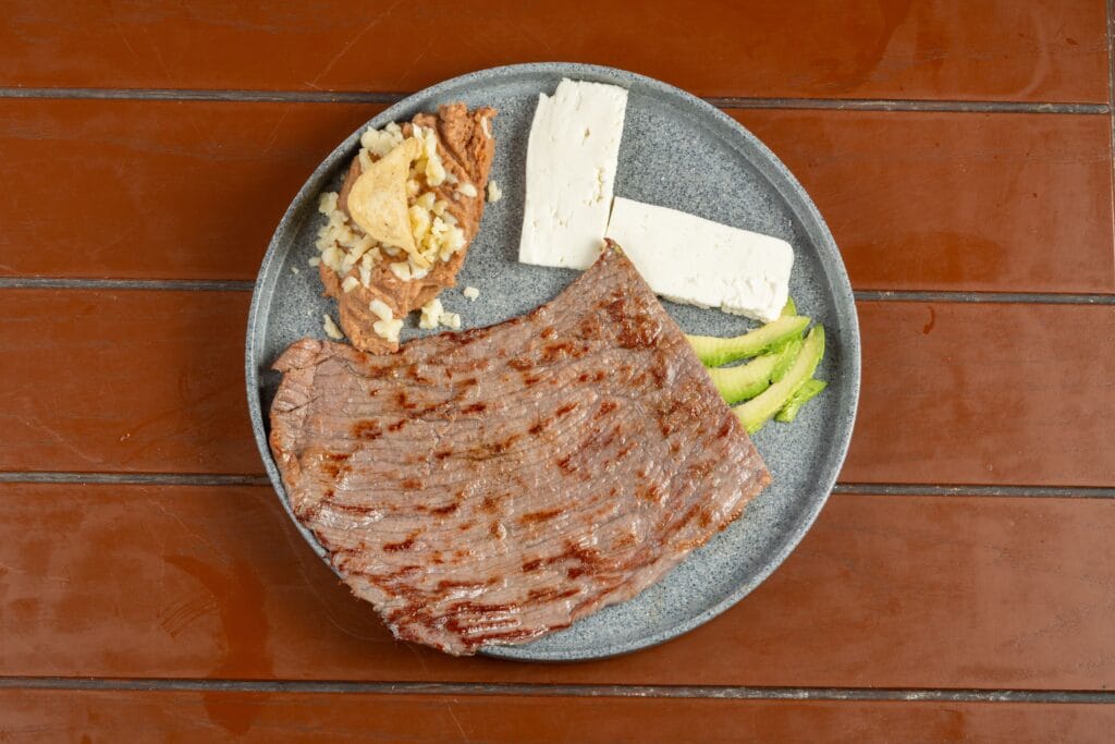 Prato com alimentos ricos em proteínas, como carne, ovos, peixe e leguminosas, representando uma alimentação equilibrada para fortalecer o organismo.