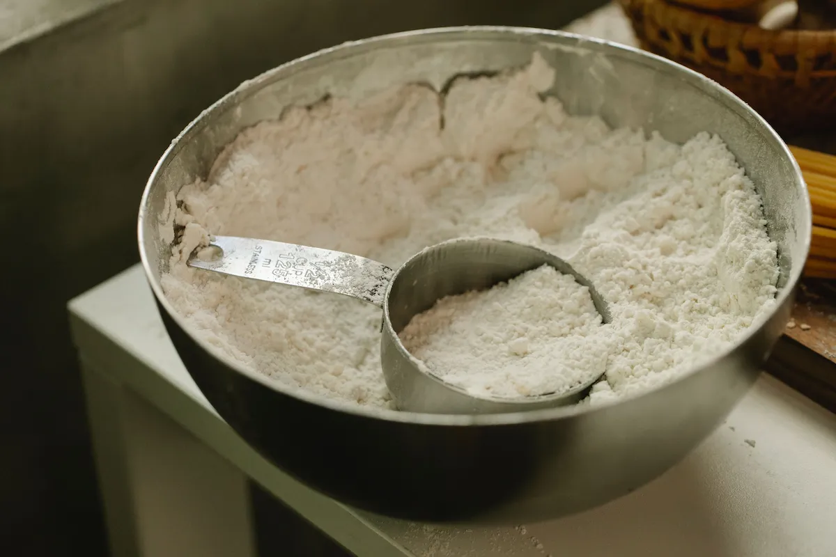 Creatina em pó com medidor dentro do recipiente, suplemento utilizado para melhorar o desempenho físico e auxiliar no ganho de força muscular.