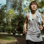 Mulher caminhando ao ar livre em um parque, mostrando os benefícios da caminhada para a saúde, o bem-estar e o condicionamento físico.