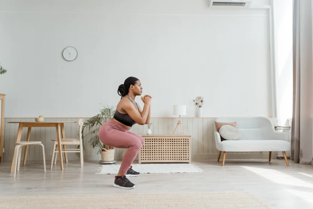 Mulher praticando exercícios físico em casa após ficar tempos sem se exercitar. Como voltar a fazer exercício depois de tempo parado?